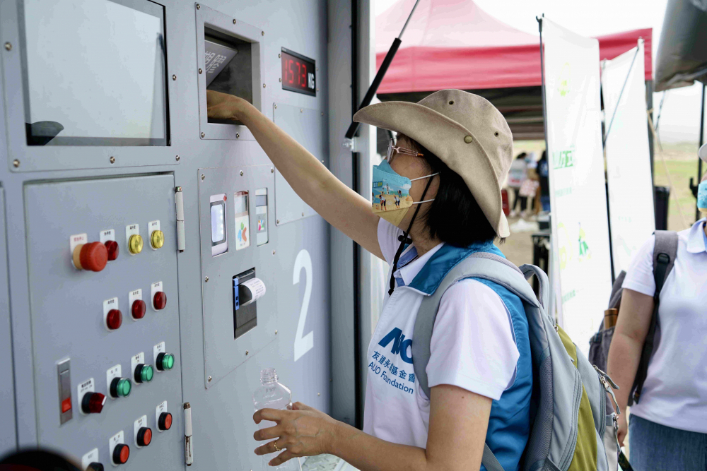 志工們將拾起的寶特瓶投入「好歸塑專車」，讓廢棄塑料空瓶可以直接粉碎、縮小體積，未來將可再製成購物袋、寶特衣、悠遊卡等生活用品